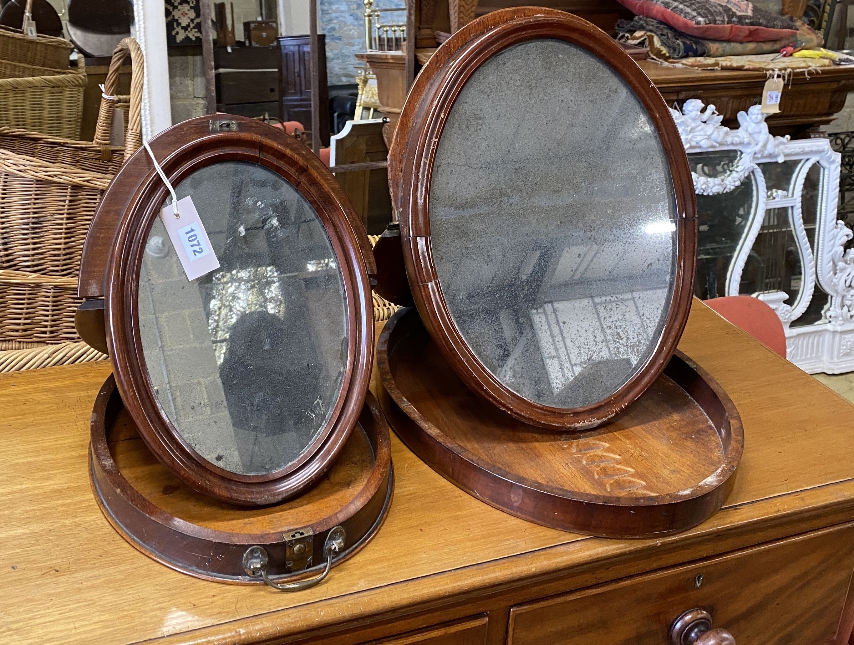 Two 19th century oval mahogany travelling toilet mirrors, larger width 36cm, height 46cm